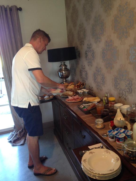 a man standing in front of a buffet of food at B&B Droomzoet in Herentals