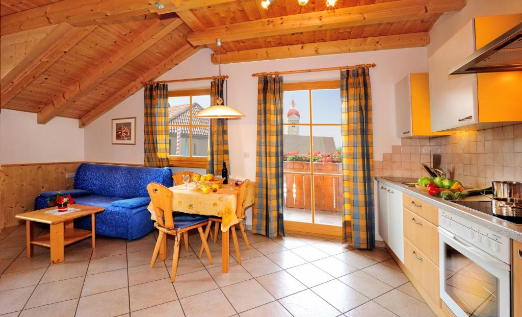 a kitchen and living room with a blue couch and a table at Ferienwohnung Walderhof Natz in Natz-Schabs