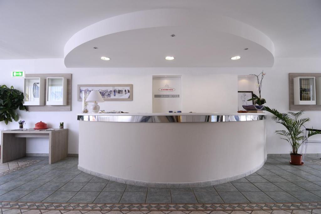 - un hall blanc avec un comptoir dans la chambre dans l'établissement Hotel Ambrosio La Corte, à Olbia