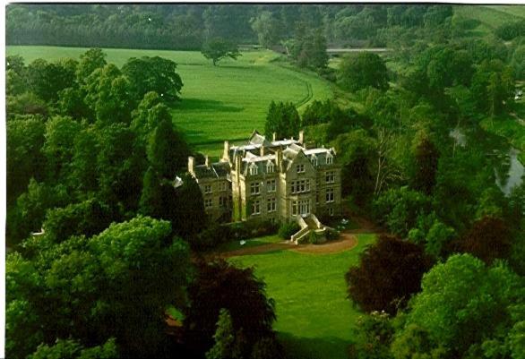 an aerial view of a large house in a field at Tillmouth Park Country House Hotel in Duddo