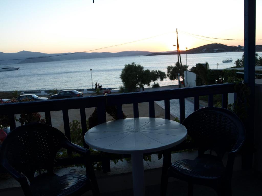 a table and chairs on a balcony with a view of the ocean at Studios Vagos 2 in Agios Prokopios
