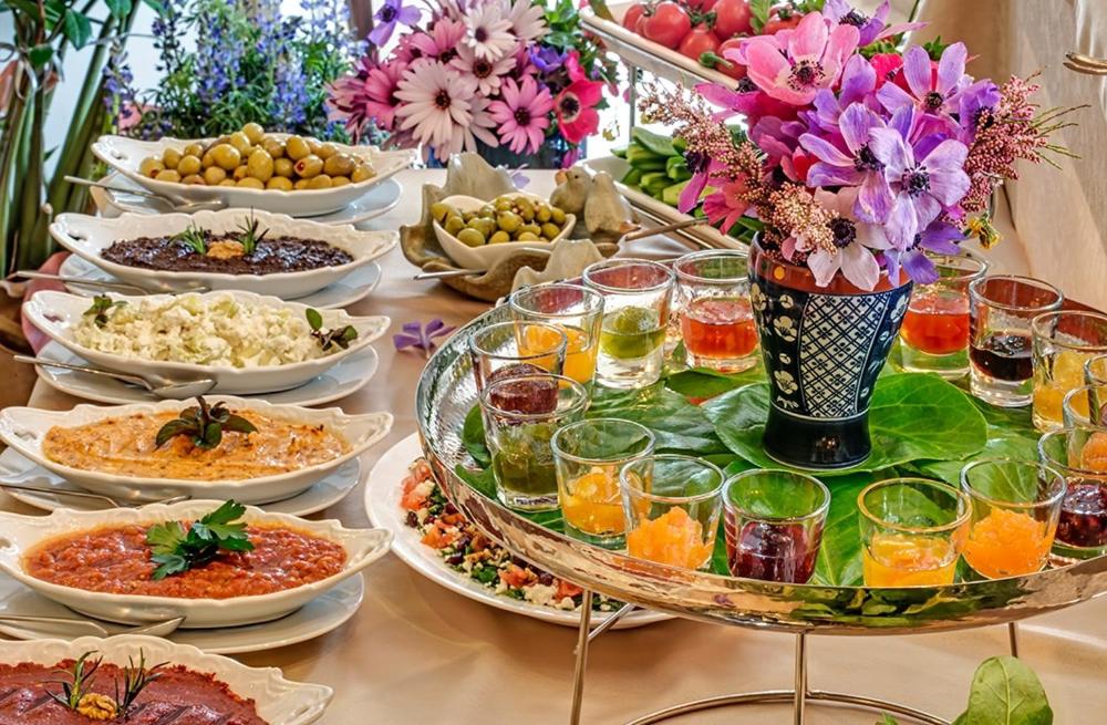 Bulbul Yuvası Boutique Hotel في فوكا: طاولة مليئة بأطباق الطعام والمشروبات