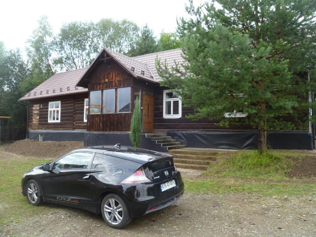 a black car parked in front of a house at Klimatyczny Domek in Sławęcin