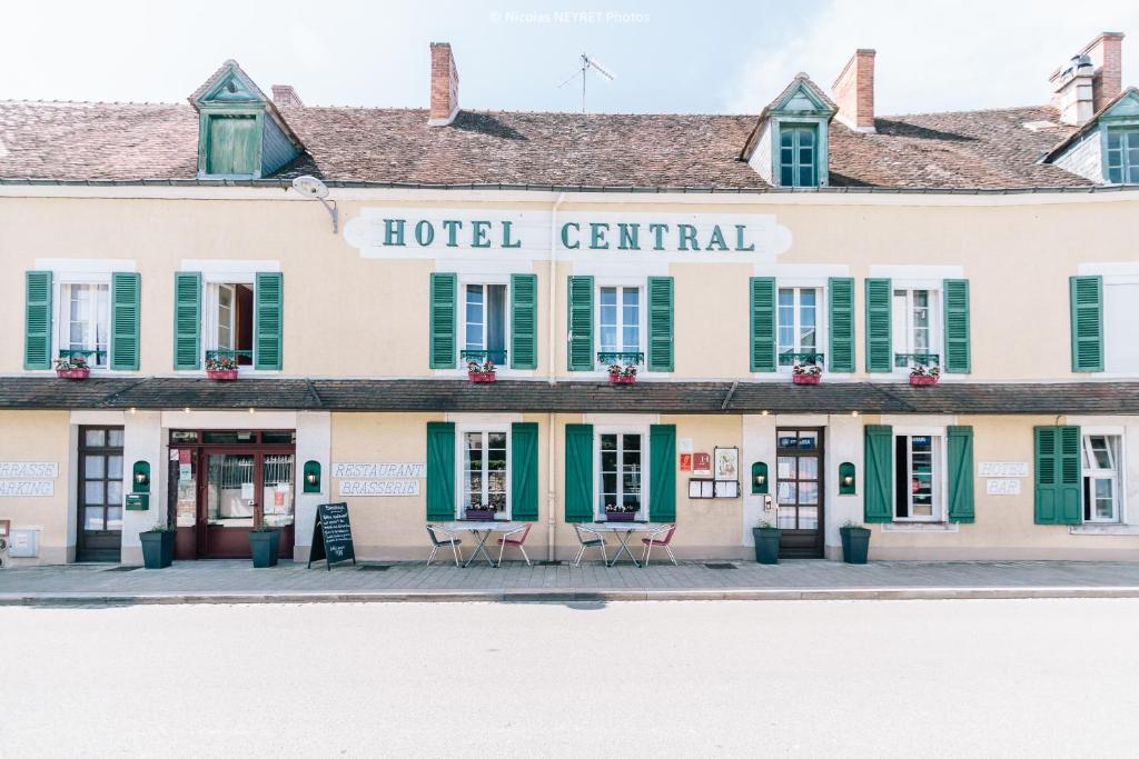 un hotel centenario con persianas verdes en Hotel Le Central en Boussac