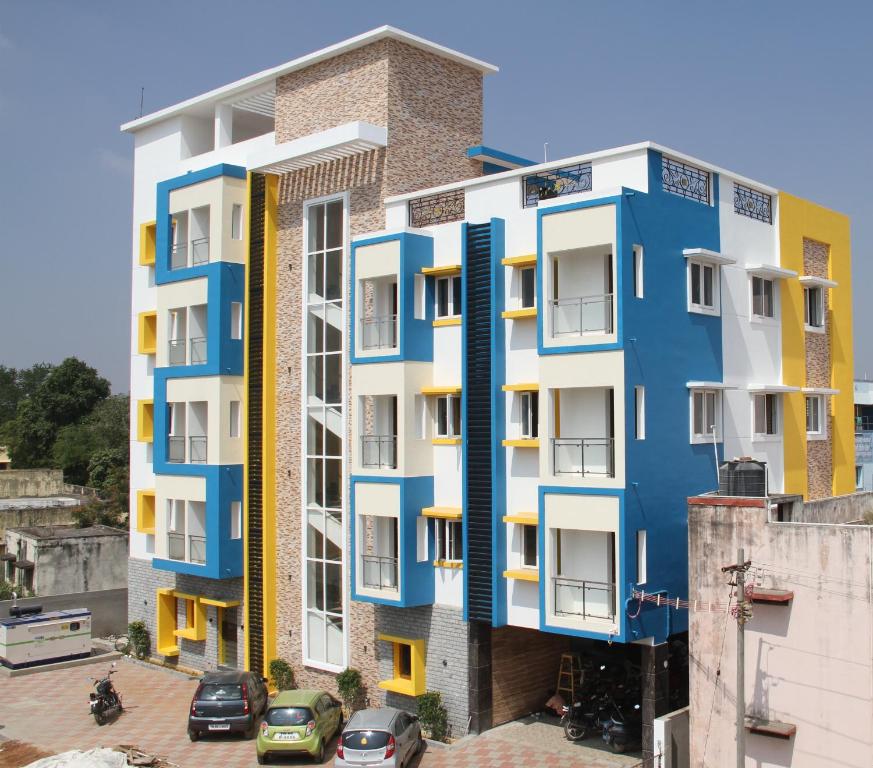 un edificio de apartamentos con fachadas azules y blancas en Jeyam Residency, en Dindigul