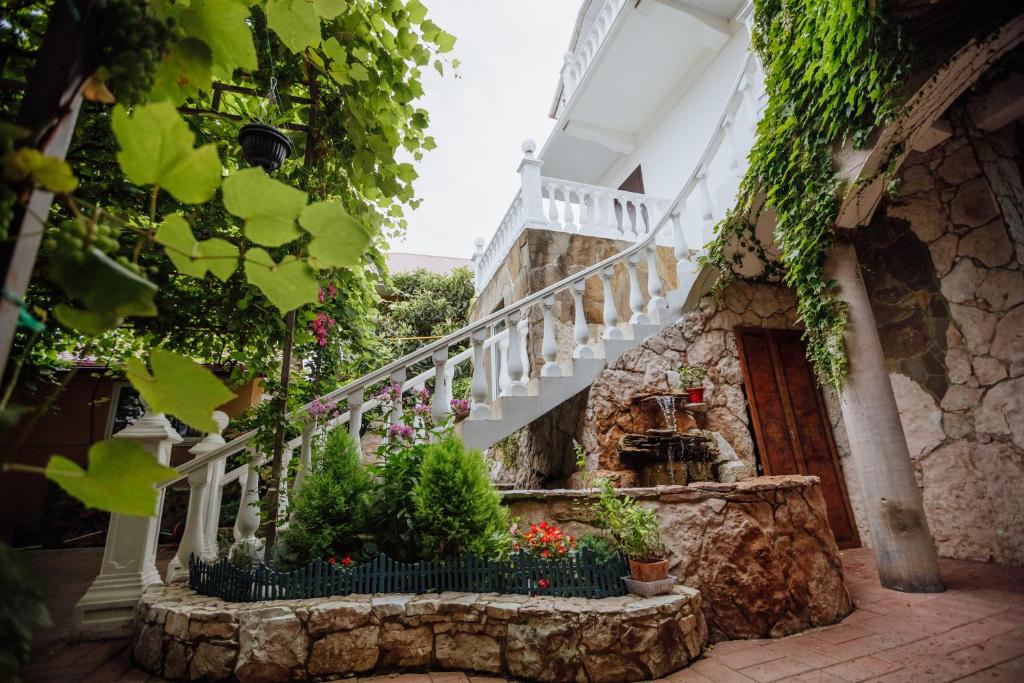 a staircase in a house with flowers and ivy at Guesthouse Laura in Adler