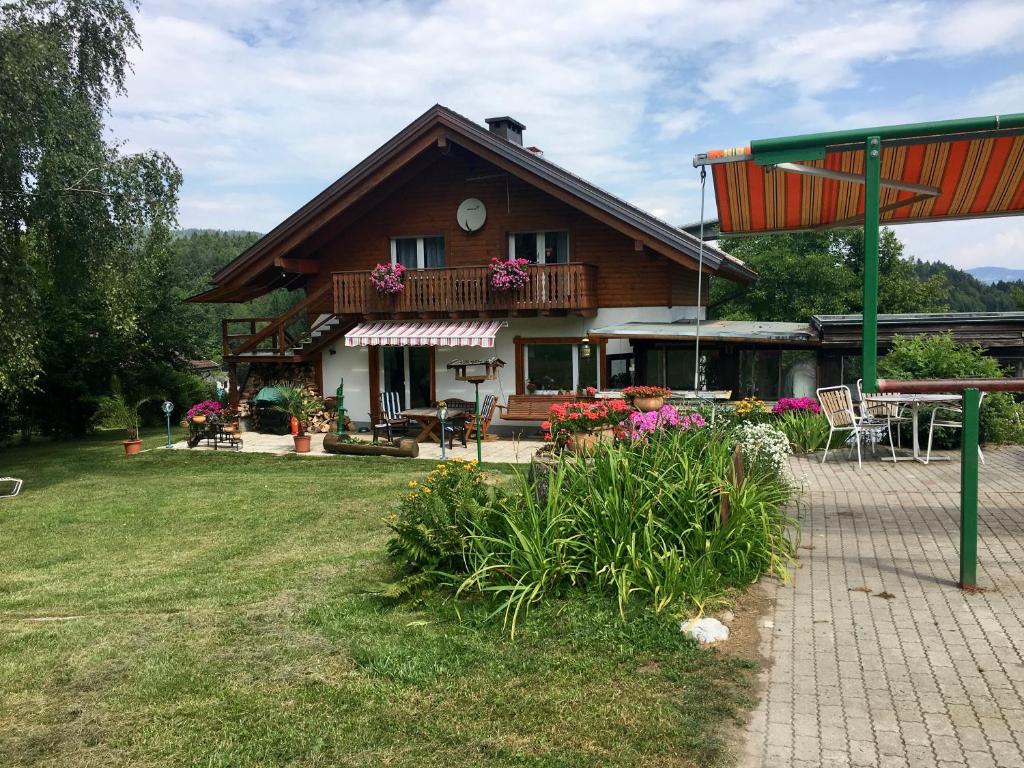 a house with a balcony and a yard with flowers at Apartment in St. Jakob im Rosental in Sankt Jakob im Rosental