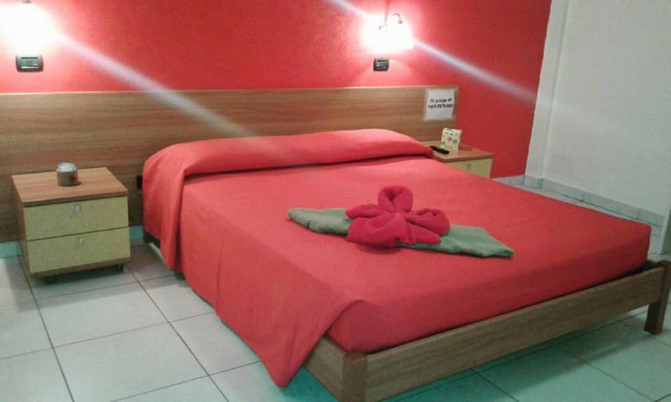 um quarto com uma cama vermelha com uma flor em "Casa di Rosa" em Margherita di Savoia