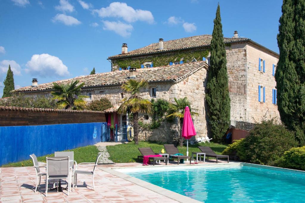 a villa with a swimming pool in front of a house at Chambres d'Hôtes et Gîtes Le Mas Bleu & Spa Resort in Rosières