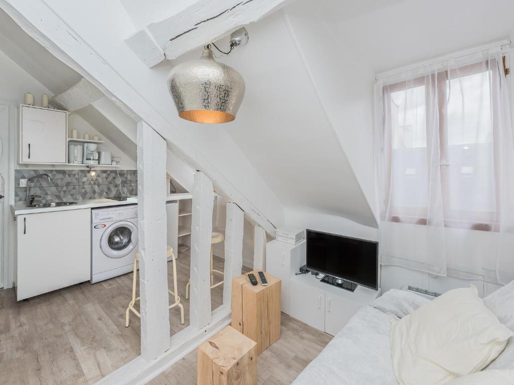 a living room with a staircase with a washer and dryer at Appartement satory in Versailles