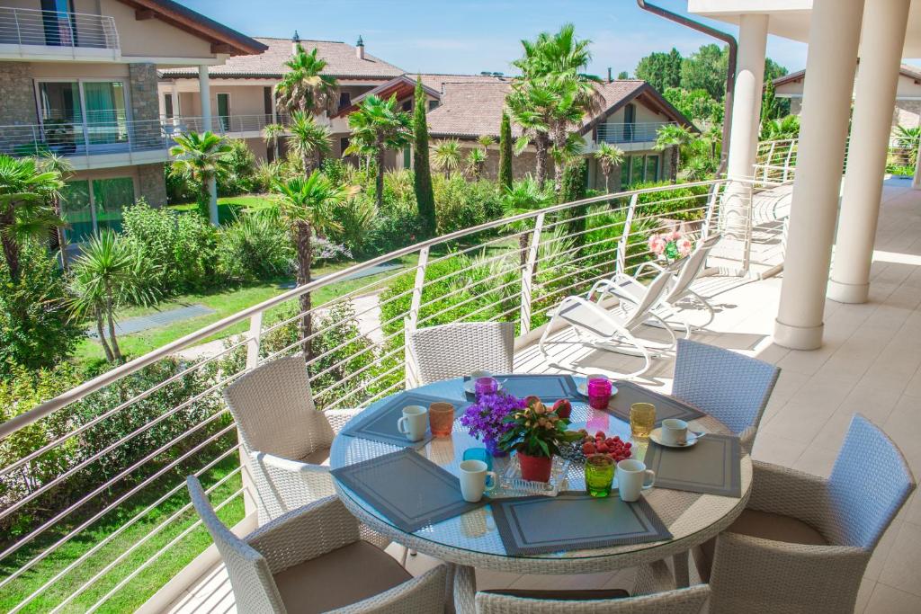 a patio with a table and chairs on a balcony at Sky Fort Garda View in Sirmione