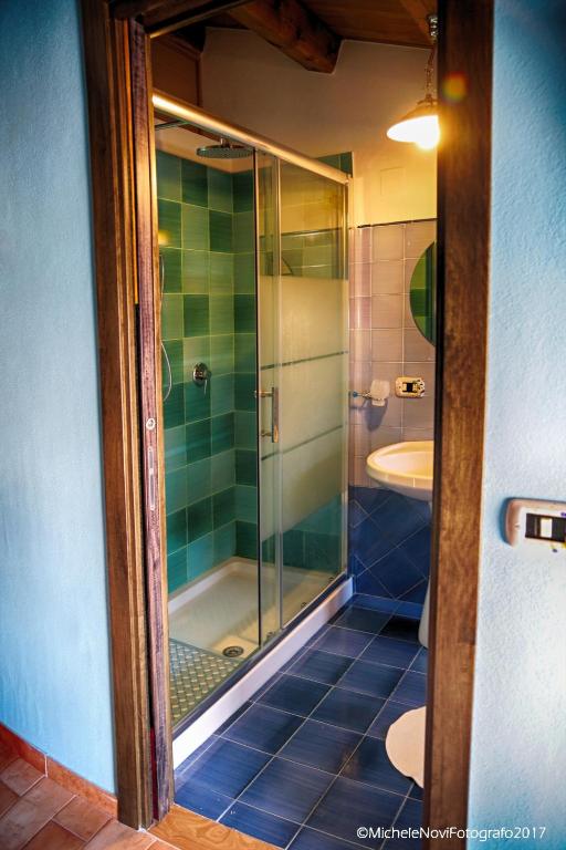 a bathroom with a glass shower and a sink at La Casa di Ivana in San Nicola Arcella