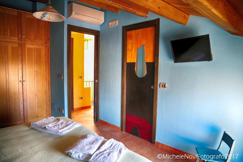 a bedroom with a bed and a tv on a wall at La Casa di Ivana in San Nicola Arcella