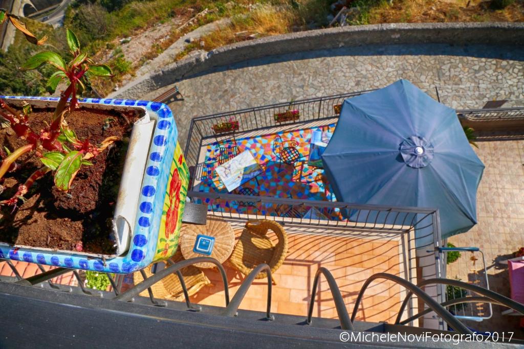 a cage with a table and a blue umbrella at La Casa di Ivana in San Nicola Arcella