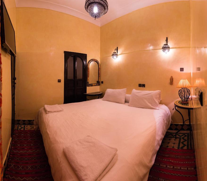 ein Schlafzimmer mit einem großen weißen Bett in einem Zimmer in der Unterkunft Riad Omar in Marrakesch