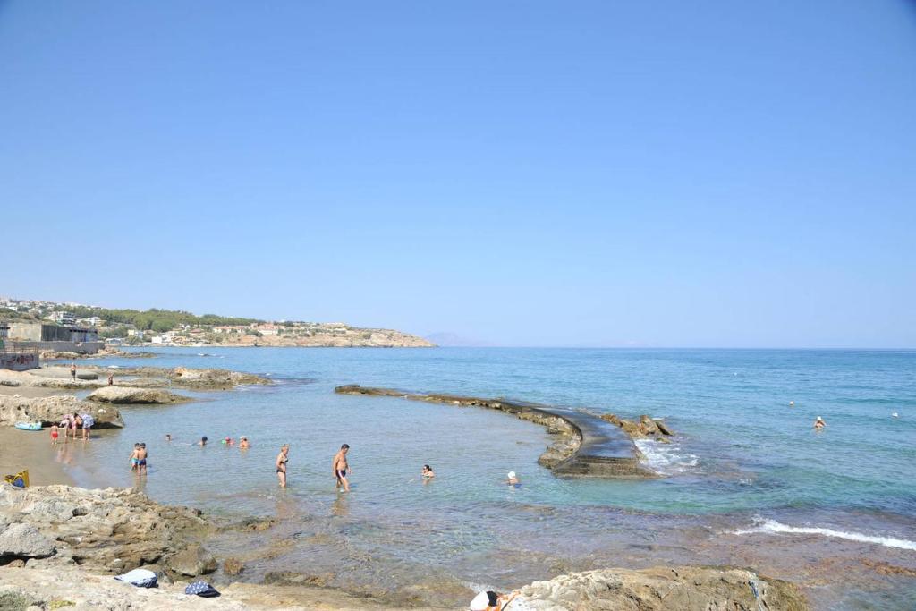 a group of people in the water at a beach at Apartment Froso on the Beach in Rethymno