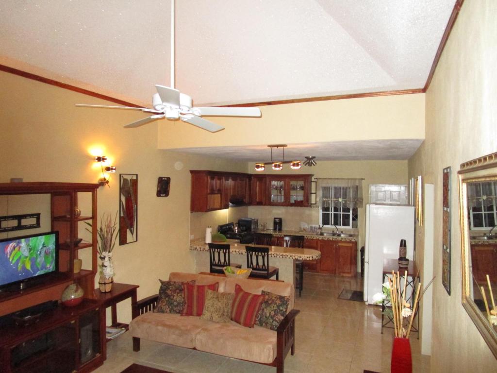 a living room with a couch and a ceiling fan at The Residence Portmore Apartments in Portmore
