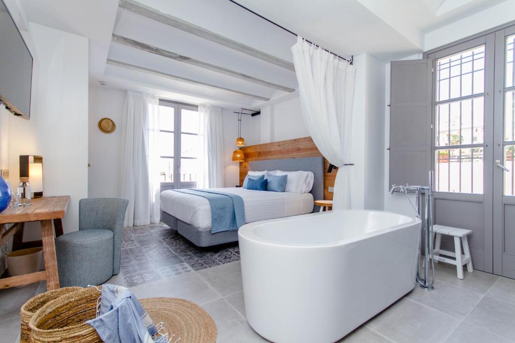 ein weißes Bad mit einem Bett und einer Badewanne in der Unterkunft Hotel Boutique La Serena - Altea in Altea
