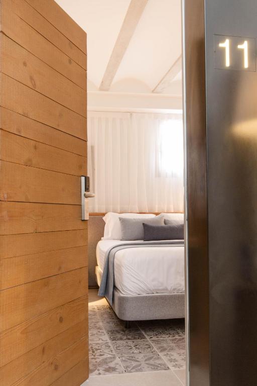 a bedroom with a bed and a door leading into a room at La Serena Boutique Hotel & Wellness - Altea in Altea