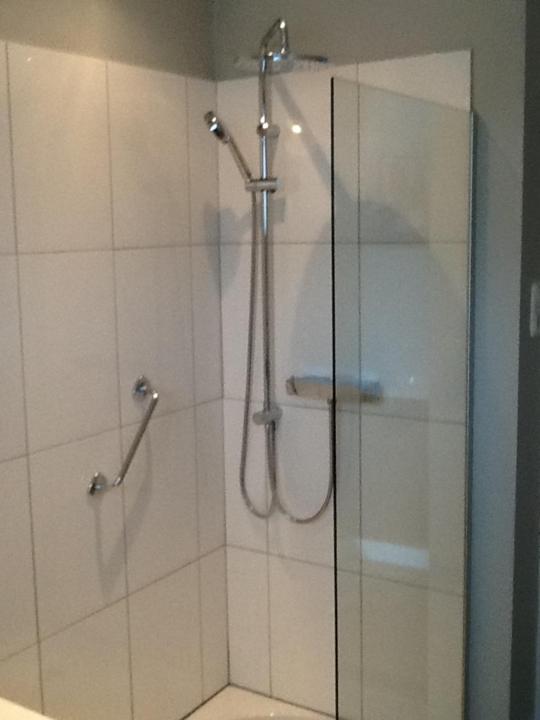 een badkamer met een douche en een glazen deur bij Het Harlekijntje in Maastricht