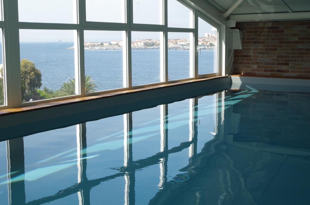 uma piscina com vista para a água em Hôtel Spunta Di Mare em Ajaccio