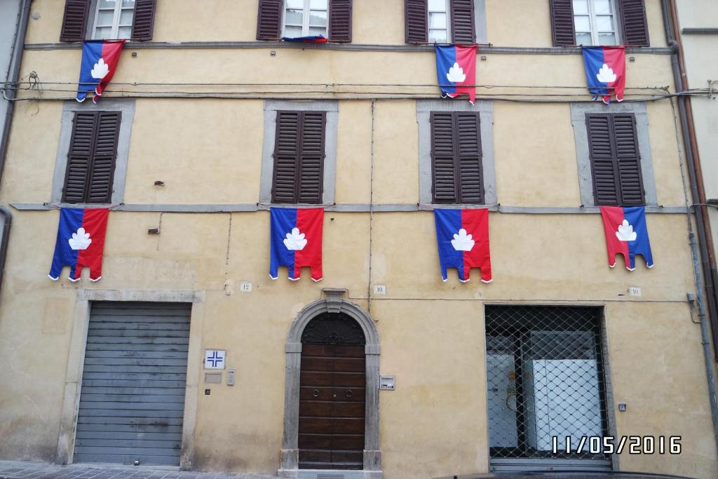 a building with red and blue flags on it at La Casetta sul Corso in Gubbio