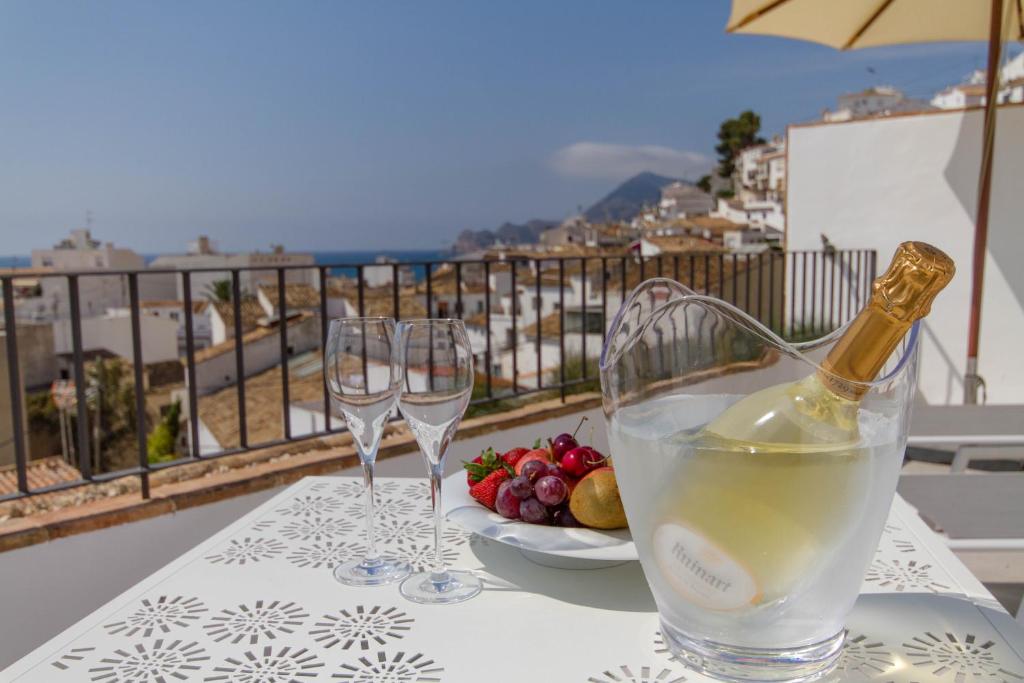 a table with two wine glasses and a plate of food at La Serena Boutique Hotel & Wellness - Altea in Altea