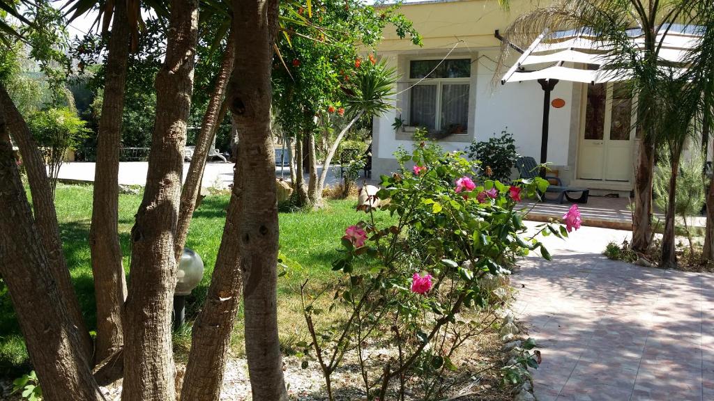 a house with trees and flowers in the yard at B&B La Gazza Ladra in Carmiano
