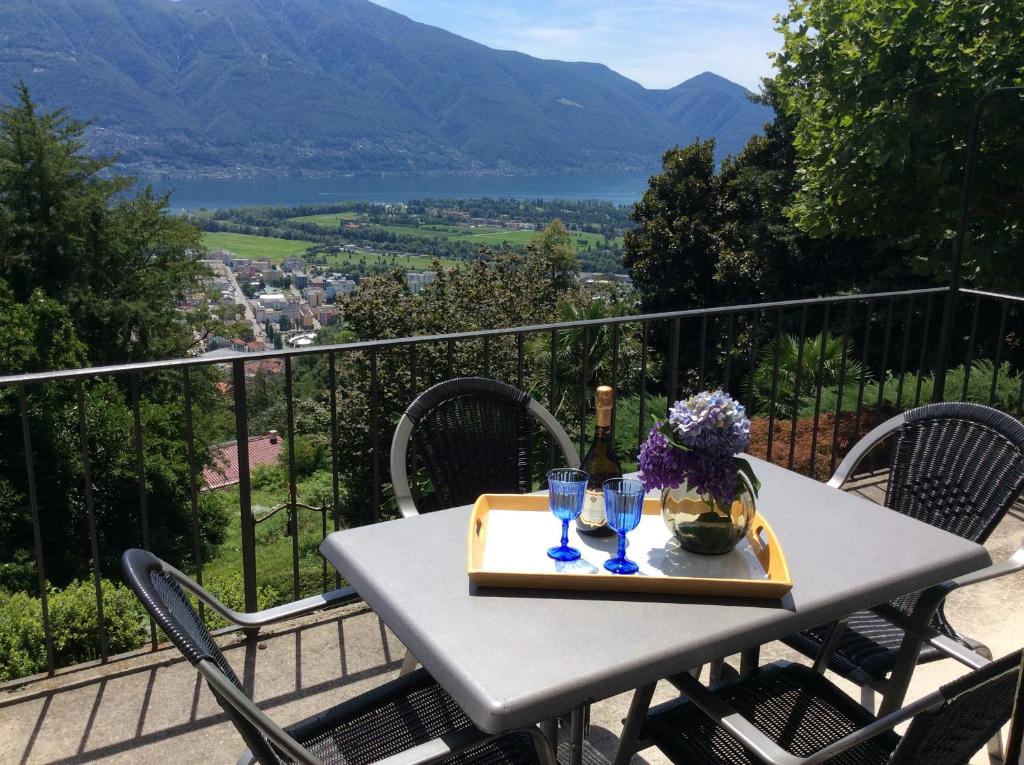 einen Tisch mit Gläsern und eine Flasche Wein auf dem Balkon in der Unterkunft Bellaterra A in Locarno