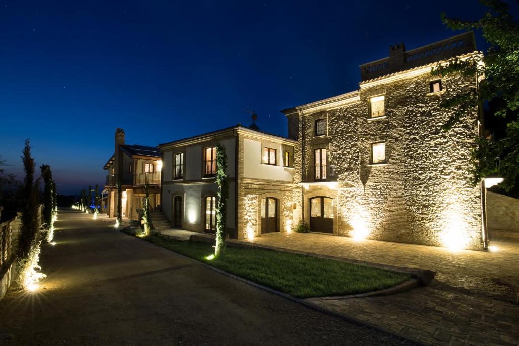 - un grand bâtiment en pierre avec des lumières sur une rue dans l'établissement Casale905, à Crecchio