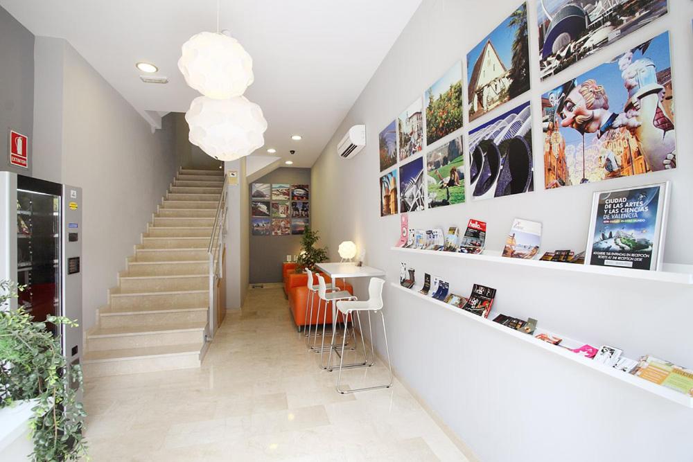 a hallway with a staircase and a stair case with pictures at Dormavalencia Hostel in Valencia