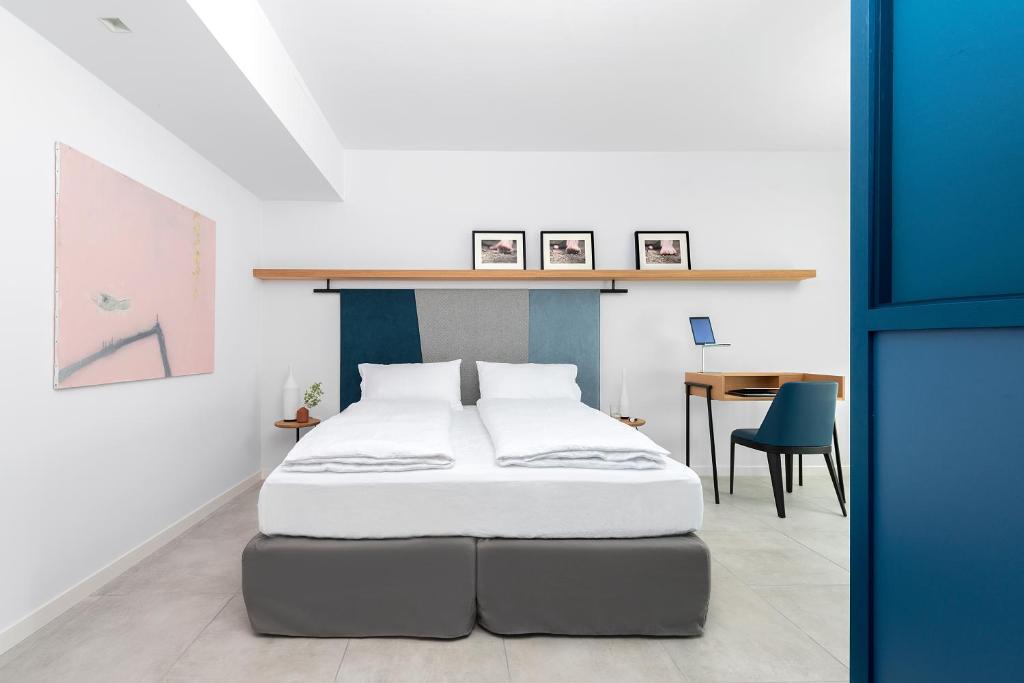 ein Schlafzimmer mit einem Bett und einem Tisch in einem Zimmer in der Unterkunft BnBiz - Coworking Hotel in Fiorenzuola dʼArda