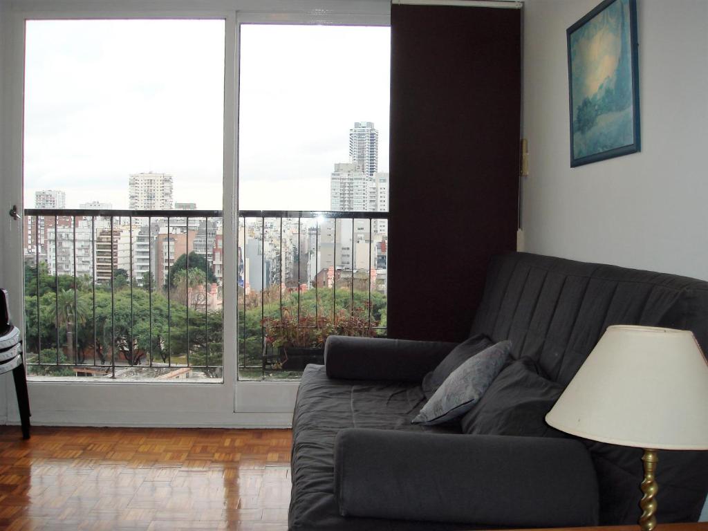 sala de estar con sofá y ventana grande en Palermo Open View en Buenos Aires