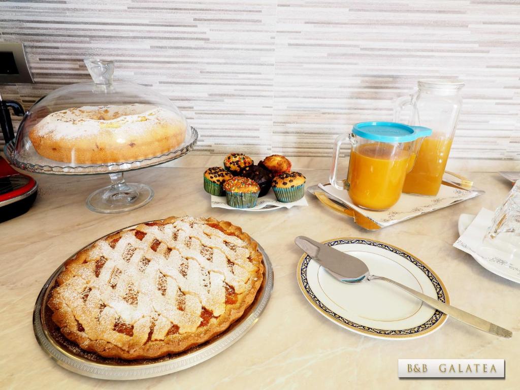 a table with a pie and some cupcakes and drinks at B&B Galatea in Santa Domenica