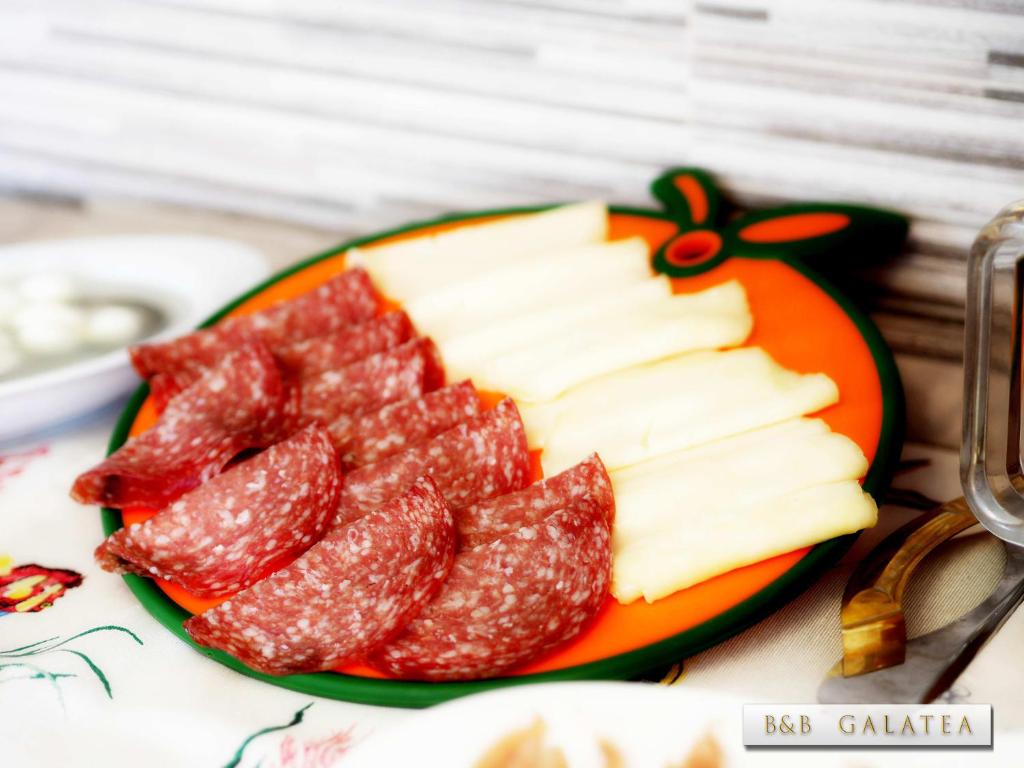 a plate of cheese and meat on a table at B&B Galatea in Santa Domenica