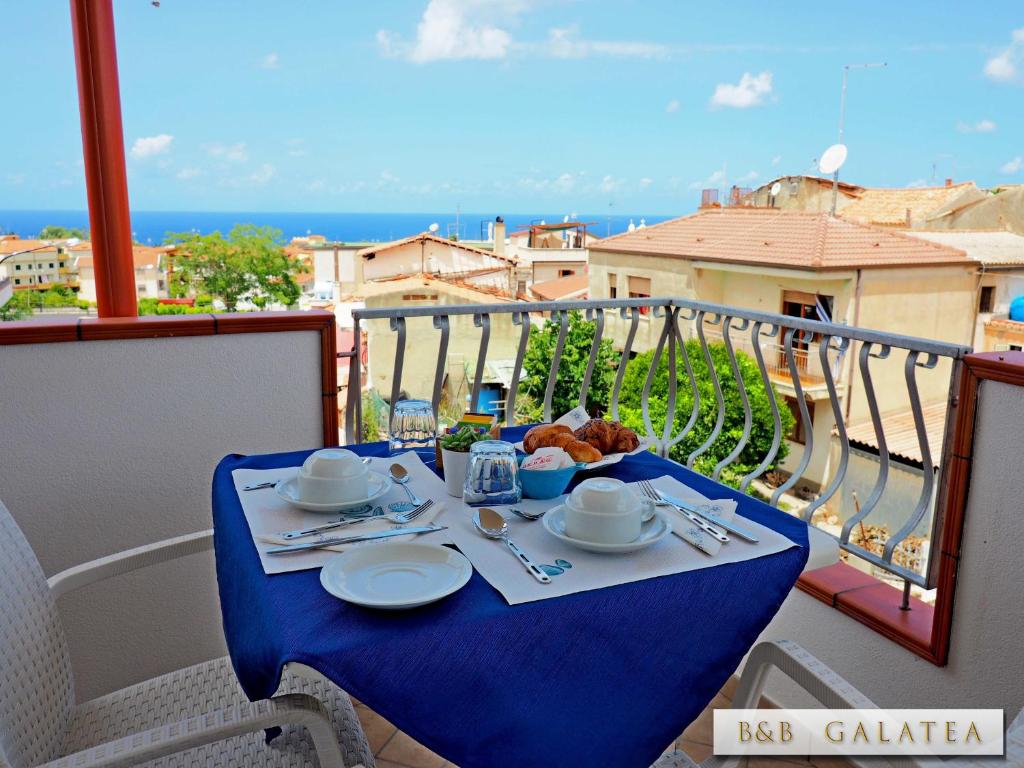 a table with a plate of food on a balcony at B&B Galatea in Santa Domenica