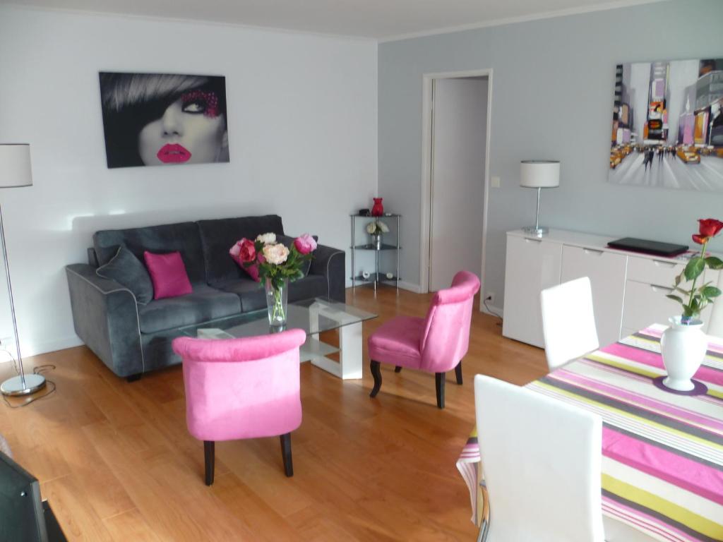 ル・テュケ・パリ・プラージュにあるResidence les Serresのリビングルーム(ソファ、ピンクの椅子とテーブル付)