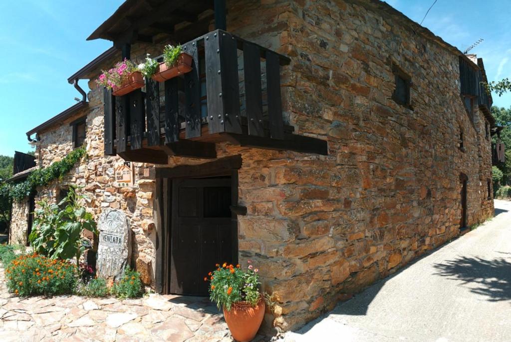 a brick building with a balcony and flowers on it at Veniata in San Pedro de las Herrerías