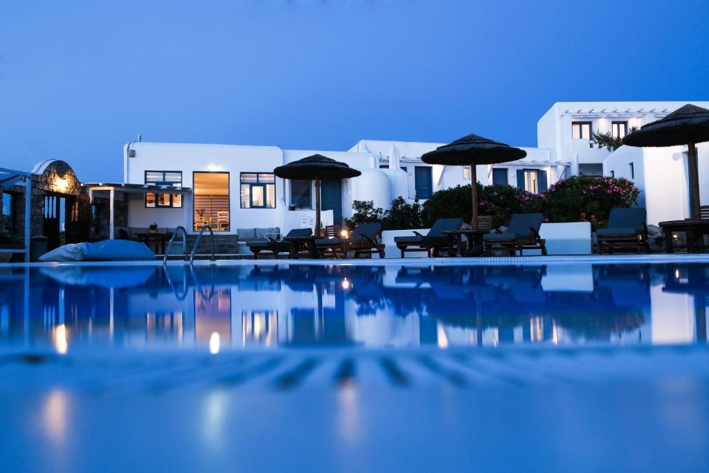 a swimming pool with umbrellas and tables and chairs at Jason Hotel in Glastros