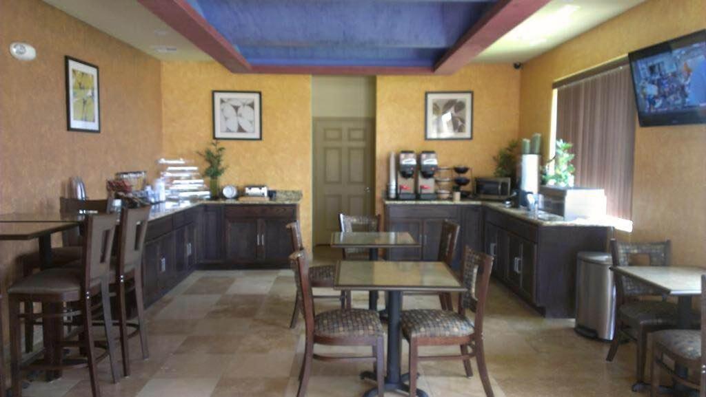 Pearsall Inn and Suites في Pearsall: غرفة طعام مع طاولات وكراسي في مطعم