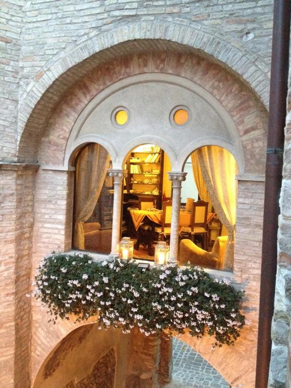 un bâtiment avec une arche et des fleurs dans une pièce dans l'établissement Palazzetto Bentivoglio, à Sassoferrato