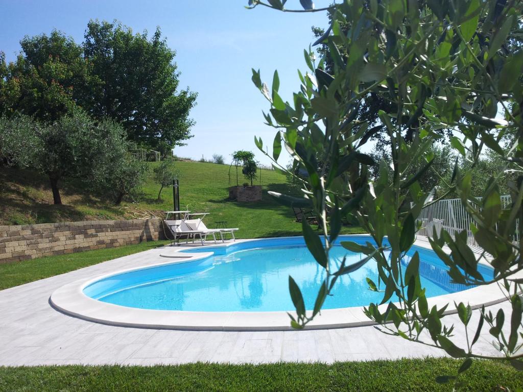 a swimming pool in a yard with a table at Podere Del Fagiano in Tolentino