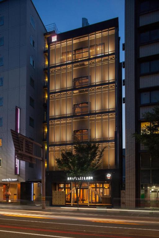 een hoog gebouw op een stadsstraat 's nachts bij Kanazawa Capsule Hotel Musashimachi in Kanazawa