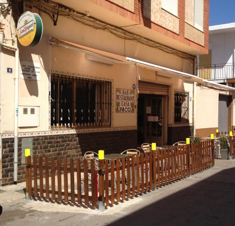 uma cerca de madeira em frente a um edifício em Hostal Casa Paco em Chilches