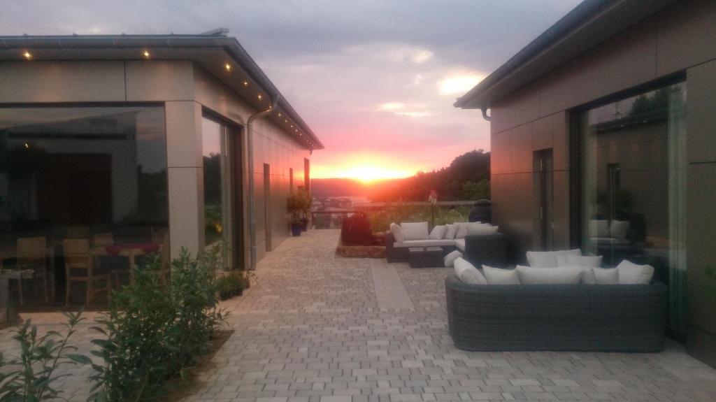 un tramonto su un patio con divani in un edificio di Kirschberghof Gästehaus und Weinverkauf a Sommerhausen