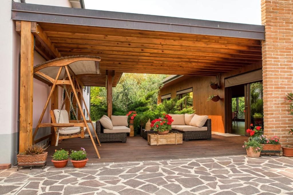 une terrasse en bois avec des canapés et une balançoire dans l'établissement Dolce Casetta, à Faenza