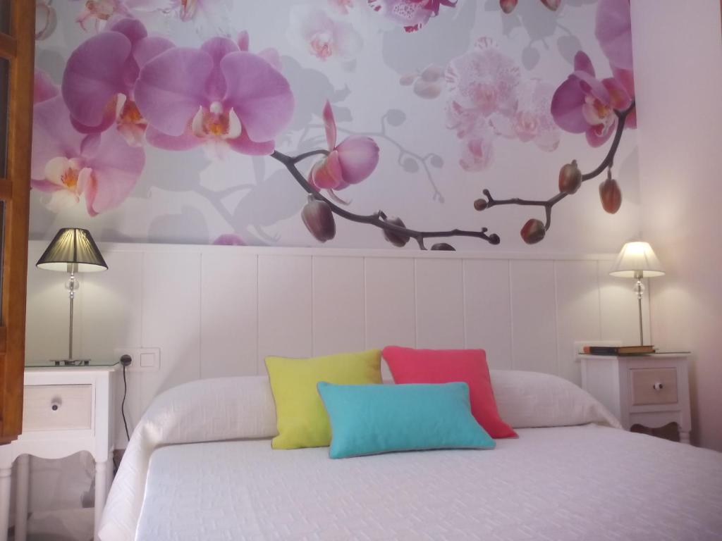 グラナダにあるApartamento Catedral Centroのベッドルーム1室(花の壁掛けのベッド1台付)