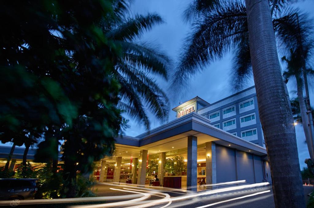 a building with palm trees in front of it at Istana Nelayan Hotel in Tangerang
