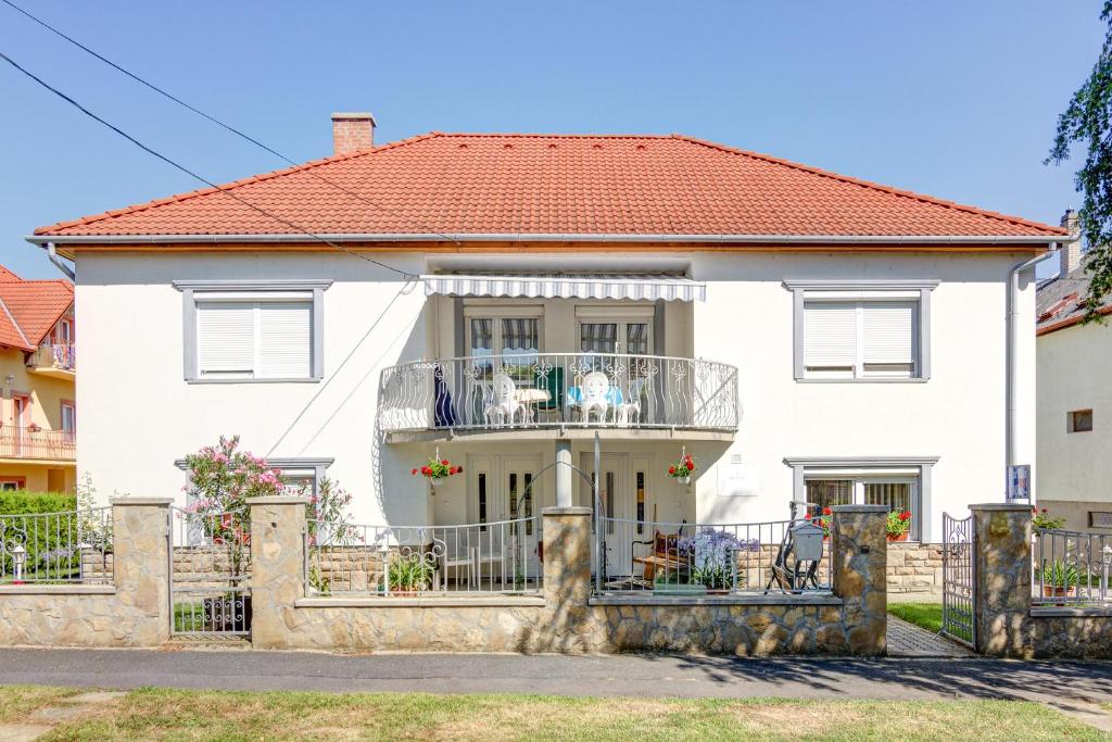 een wit huis met een balkon ervoor bij Ilona Apartman Hévíz in Hévíz