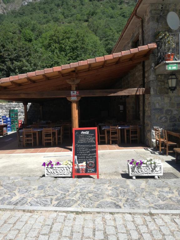 a restaurant with a sign in front of a building at Hostal Casa Tino in Caín